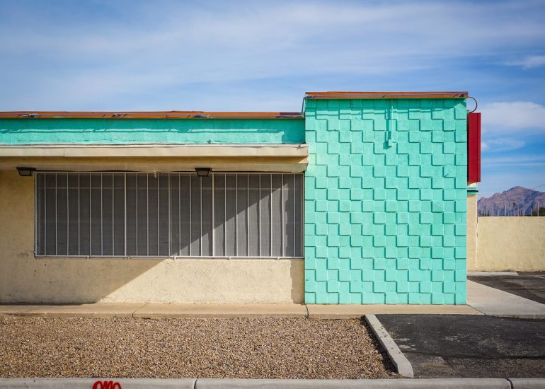 vintage red and white car in front of old motel