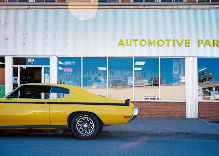 vintage red and white car in front of old motel