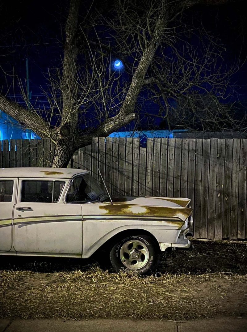 vintage red and white car in front of old motel